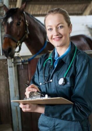 Dr. G Dr. G standing with clipboard in barn setting